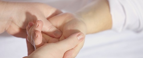 Terapeuta masajea las manos de un paciente