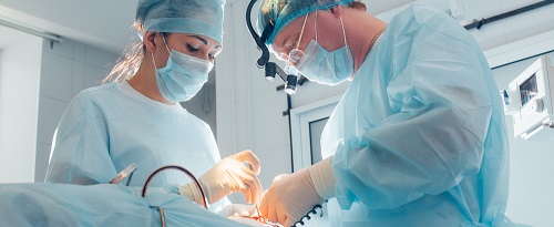 Un doctor y una doctora realizan una cirugía