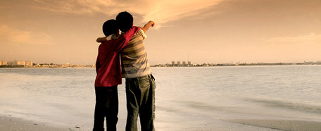Dos niños abrazados miran el horizonte