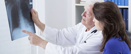doctor le muestra una radiografía a su paciente