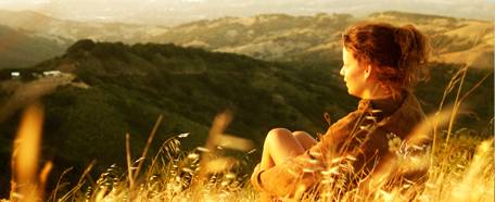Mujer sentada en una llanura contempla el horizonte