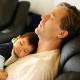 Padre duerme con su hijo sobre un sofá.