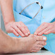Terapeuta toca el pie de un paciente.
