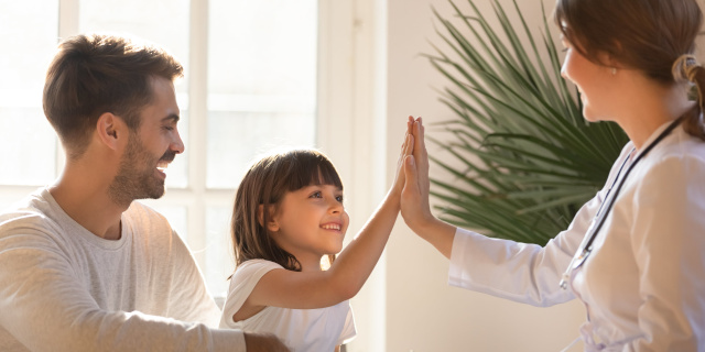 Niña chocando la mano con una doctora