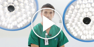 Toma frontal de un doctor con un foco reflector a cada lado suyo