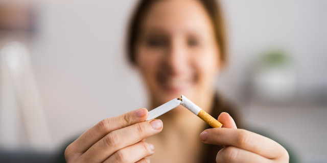 Mujer apagando 2 cigarros entre sí