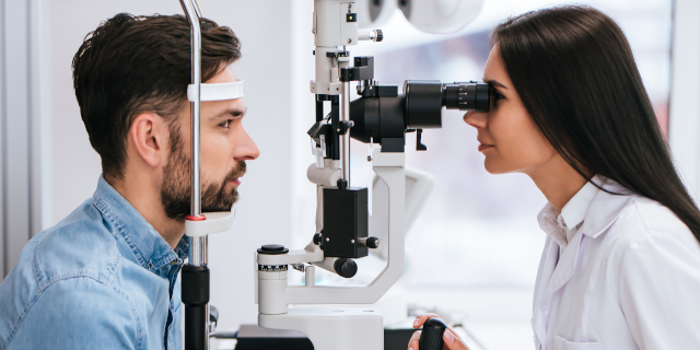 doctora oftalmóloga está revisando la visión ocular de un joven