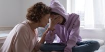 Madre joven preocupada consolando a una hija adolescente