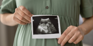  joven embarazada sosteniendo una imagen sonográfica del bebé