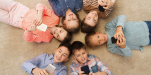 niños en el suelo mirando su celular