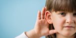 Niño con problemas auditivos en fondo azul