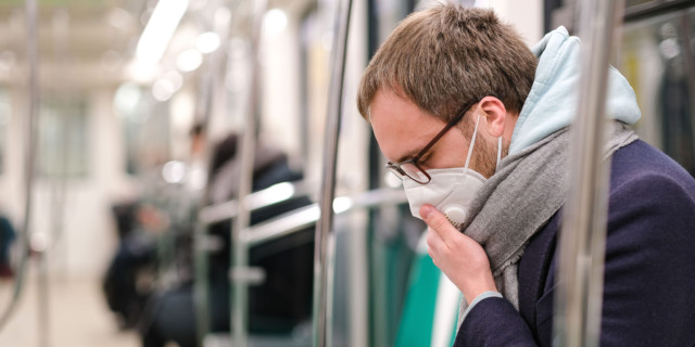 Hombre en metro con bufanda y mascarilla