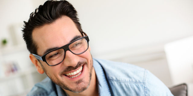 Hombre con lentes ríe feliz