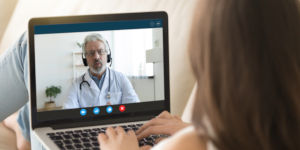Doctor se comunica con paciente mediante computador