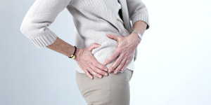 Mujer con manos en cadera por dolor debido a pinzamiento o pellizcamiento