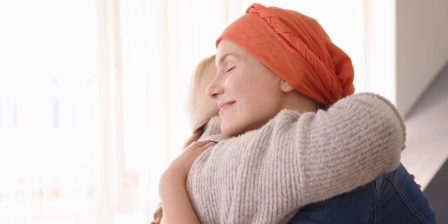 mujer con cancer abrazando a familiar