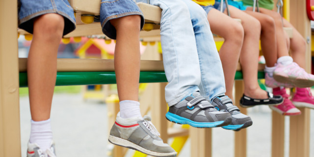 Niños con sus pies al aire mostrando sus zapatillas