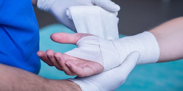 Doctor inmovilizando muñeca de paciente