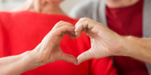 pareja de edad que muestra gesto del corazón con sus manos