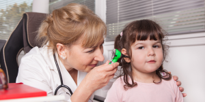 doctora inspeccionando oído a niña
