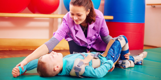 Terapeuta realiza fisioterapia en niño