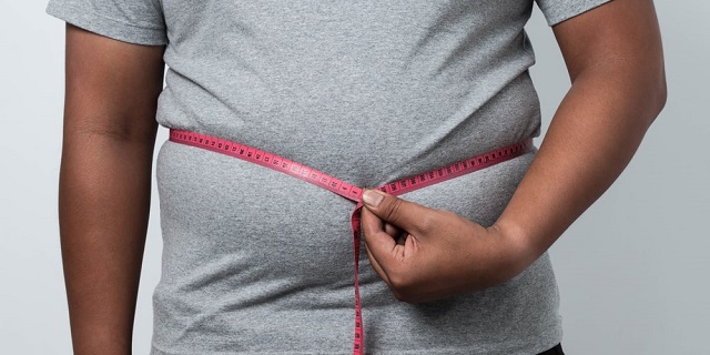 Hombre obeso con cinta para medir alrededor de su cintura