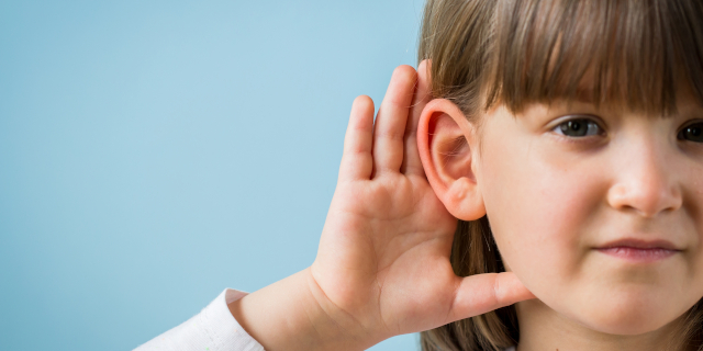 Niño con problemas auditivos en fondo azul