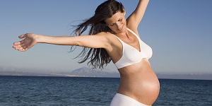 Mujer embarazada feliz en una playa