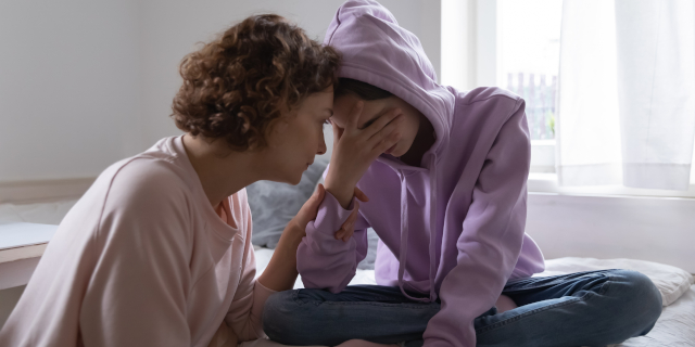 Madre joven preocupada consolando a una hija adolescente