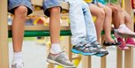 Niños con sus pies al aire mostrando sus zapatillas