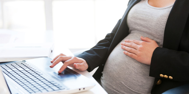 Mujer embarazada trabaja en su computador