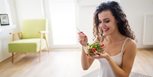 Mujer comiendo un bowl de ensalada en su casa