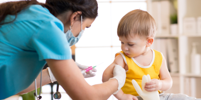 Enfermera vacunando a niña