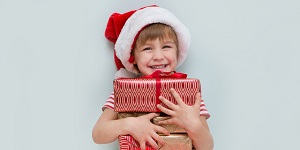 Niño feliz con regalos de navidad en sus manos