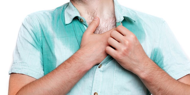 Paciente con su camisa mojada por sudoración, signo de hiperhidrosis